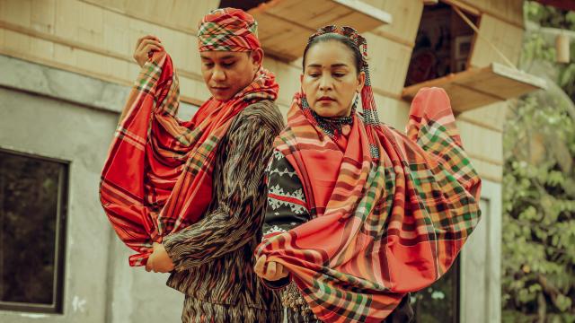 Helobung by Rmeo Muyco Espina Two people standing back to back, wearing traditional Filipino clothing