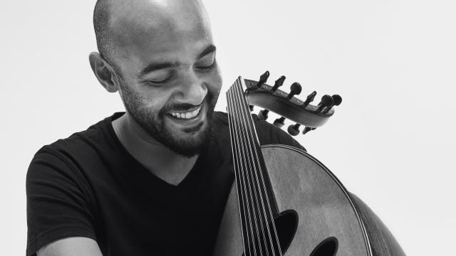 Momhamed Abozekry by Khaled Gohar A black and white portrait of a man in a black t-shirt holding an oud.