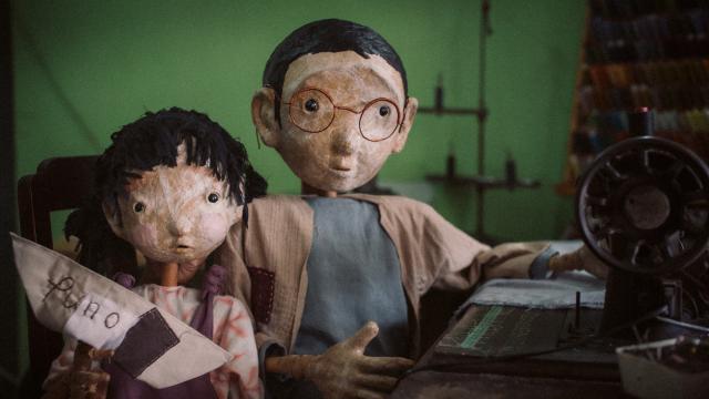 Puno, Sewing Memories, photo by Rangga Yudhistir Two puppets looking at the camera, one with a sewing machine and one with a small boat