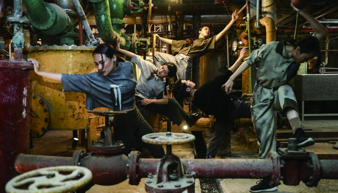 Resident Island Dance Theatre by Huang Jyong Jhe Dancers posing in the underbelly of a factory space