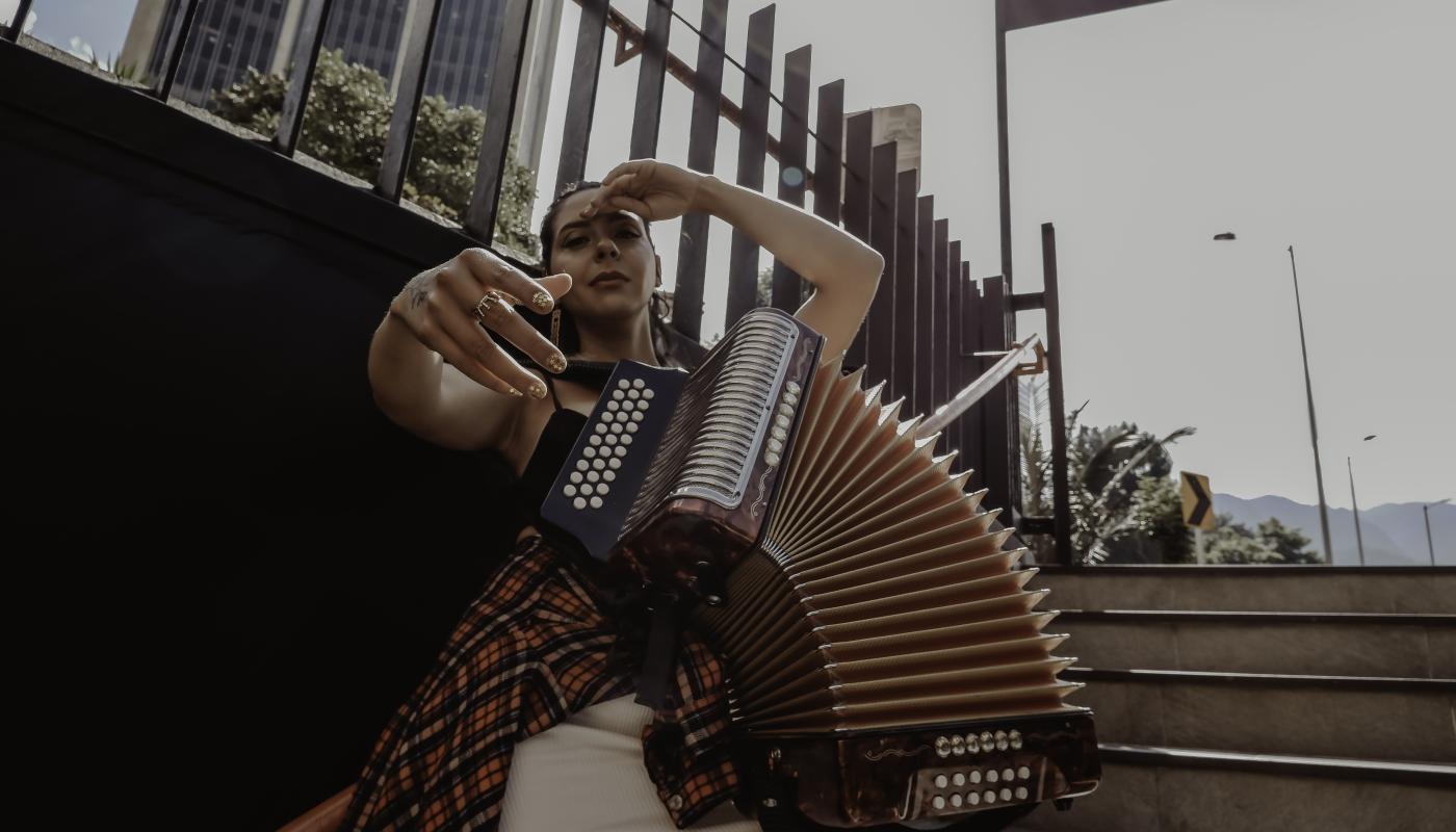 A woman sitting on steps with an accordion
