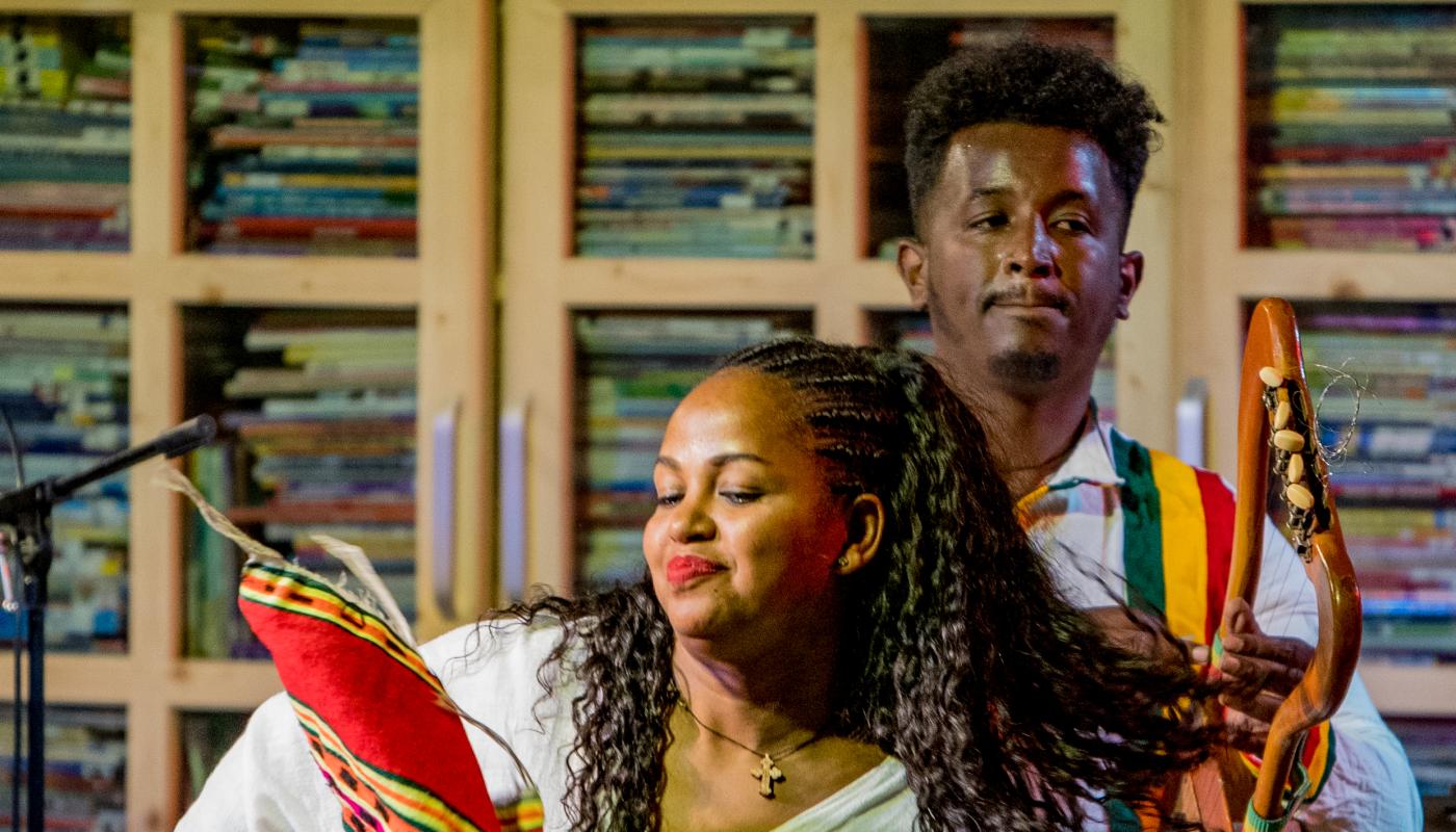 Two musicians performing on stage with traditional instruments