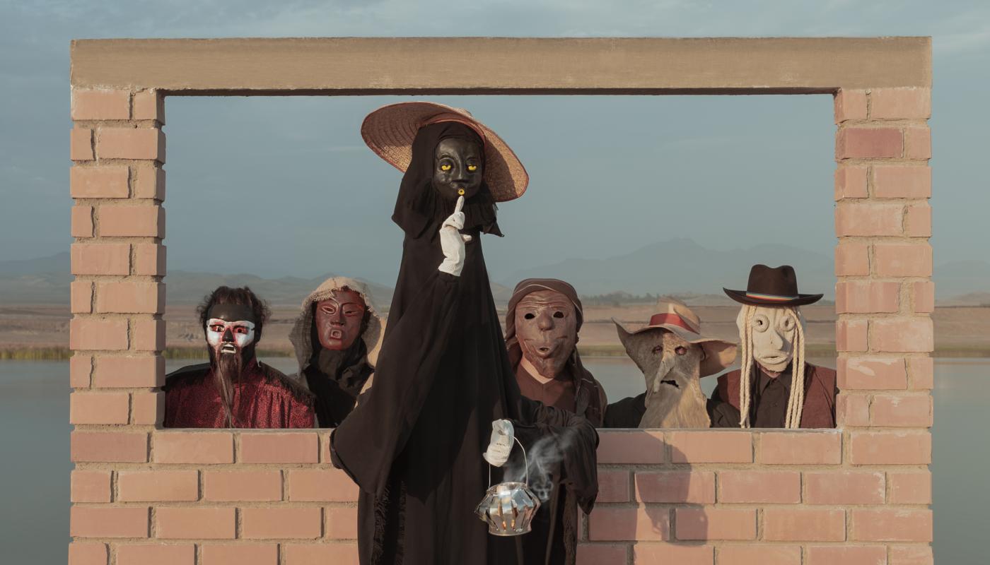 Hit La Rosa, Courtesy of Hit La Rosa (3) 5 people wearing masks in front of a brick structure