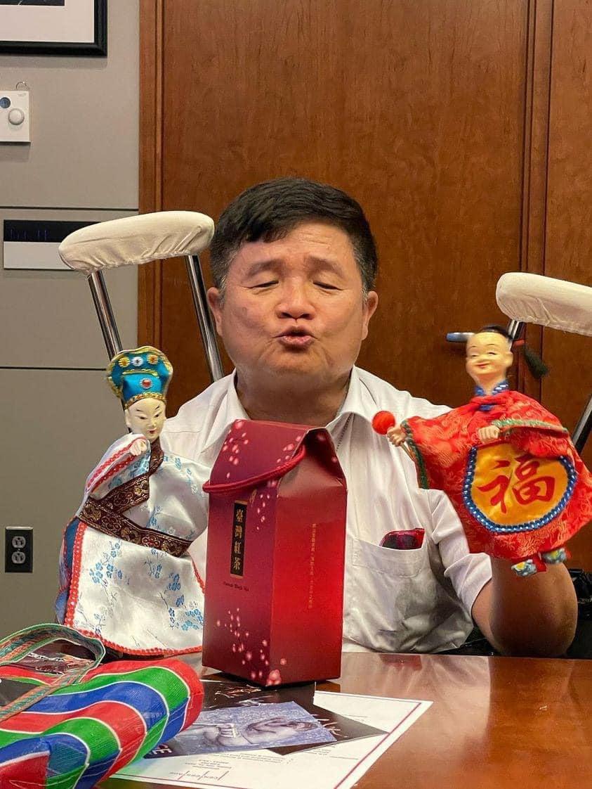 A man holds two traditional Taiwanese puppets