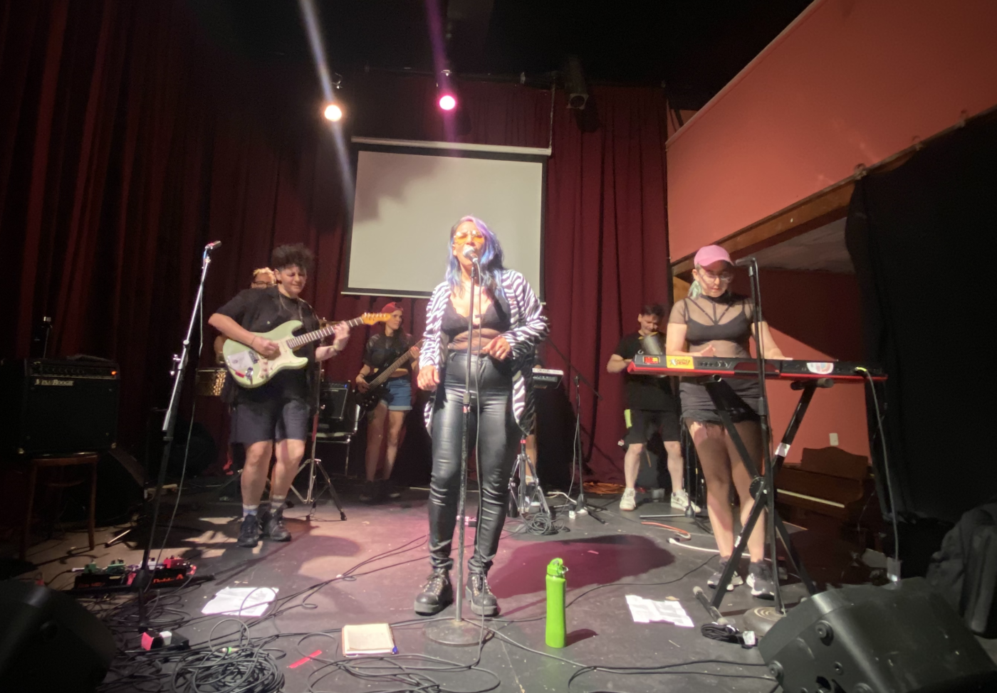Cachitas Now! Baltimore MD by Aketzali Vazquez A band performs on a small stage, fronted by a woman in a zebra-print jacket