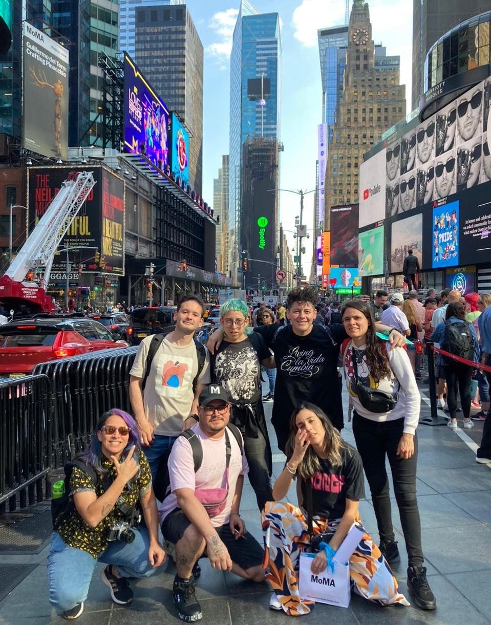 A group of seven people pose for a photo in New York City's Times Square