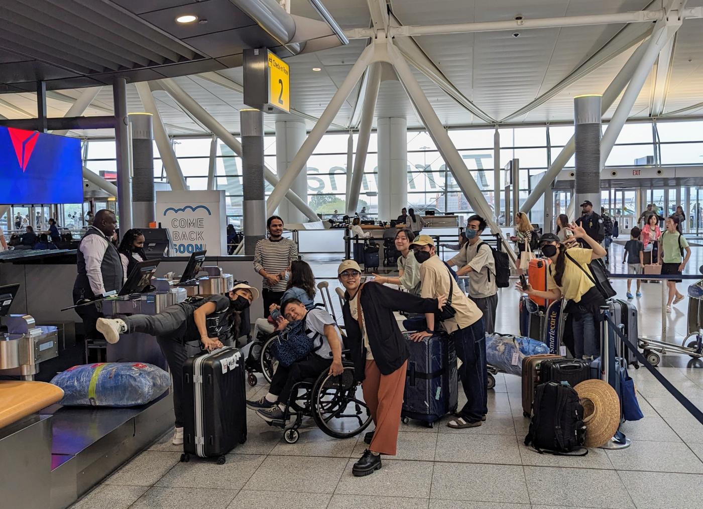 A group of people wait to check in at an airport