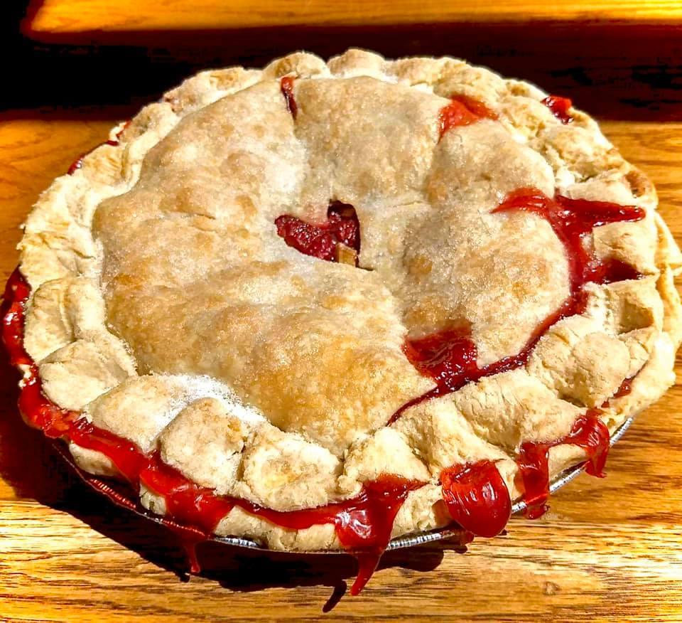 Strawberry Rhubarb Pie A photo of a strawberry rhubarb pie with a heart cut out in the middle of the crust