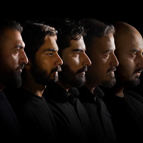 Five men in black shirts, lined up, photographed in silhouette